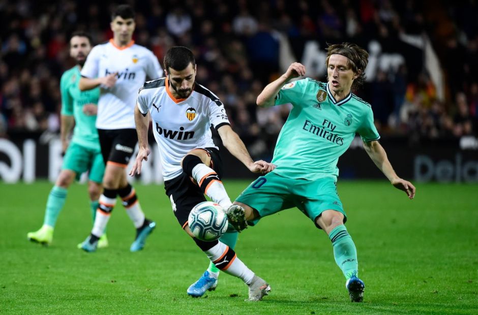 Cầu thủ Valencia trong trang phục áo màu trắng đang tranh chấp bóng với Modric của Real Madrid